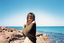 A young woman wearing an off-the-shoulder on the beach