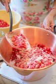 Lingon berry jam being made, raw lingon berries in a pot with sugar