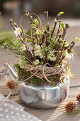 Bouquet of barbara branches in a silver teapot