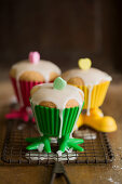 Lemon muffins with icing in colourful plastic cases with legs