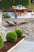 Buchsbaumkugeln am Weg zur Terrasse mit Sand und Sitzplatz