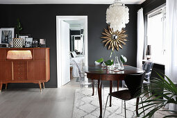 Eclectic mixture of styles in dining room with black walls
