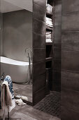 Modernes Bad in Grau mit offener Dusche und eingebauten Regalen