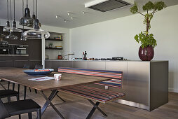 Long dining table with benches and chairs in modern kitchen-dining room