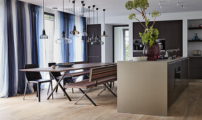 Long dining table with benches and chairs in modern kitchen-dining room