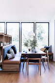 Shelf with integrated bench as a room divider and dining table with chairs