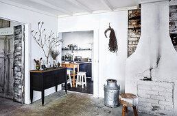 Brick wall, stool, milk can and sideboard in front of the passage