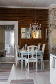 Set table and chairs below chandelier decorated with old silver cutlery