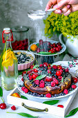 Sommerliche Obsttorte mit Beeren, Aprikosen, Kirschen und Puderzucker