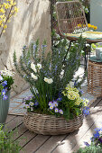 Terrace arrangement with rosemary and spring flowers in a basket