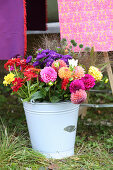 Bunter Herbstblumenstrauß im alten Metalleimer