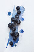 Blueberries over blue water colour painted surface