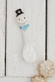 A snowman spoon with powdered sugar and cookies