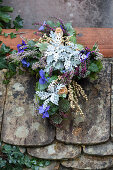 Cross planted with silver ragweed, heather and violas decorating grave