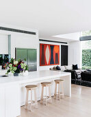 White, open kitchen with kitchen counter and bar stools