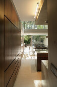 View from modern fitted kitchen into dining room and through into courtyard