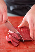 Trimmed and soaked beef heart being sliced