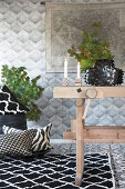 Rustic wooden table, black-and-white rug and cushions