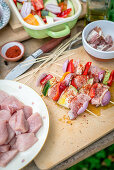 Meat and vegetable skewers ready for grilling on a wooden board