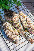 Grilled fish with herbs on a grilling basket