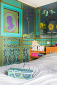 Bed in bedroom with ornate Oriental-style wallpaper