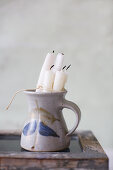 Candles in ceramic jug