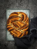 Plaited bread with chocolate and cinnamon on a baking tray