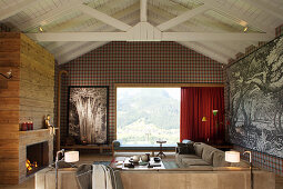 Elegantes Wohnzimmer mit Kamin und Holzverkleidung, Panoramafenster mit Landschaftsblick