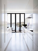 weiße Designerküche mit Balkontür und Meerblick