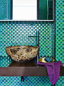 Wash basin in the bathroom with green mosaic tiles
