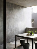 Table with house plants and designer stool on balcony