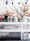 Roses in glass vases, glass jars on the shelf