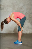 A young woman performing a back stretch