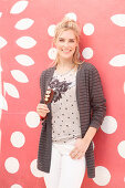 A blonde woman wearing a top and a cardigan with an ice cream