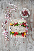 Vegane Sandwiches gefüllt mit Hummus und Gemüse (Paprika, Radieschen, Avocado)