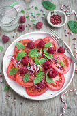 Summer salad with tomatoes, raspberries, red onion and mint