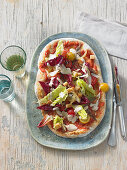 An autumnal Caesar salad with a salted lemon dressing on an anchovy pizza