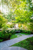 Path with gray stone slabs in the lush green garden