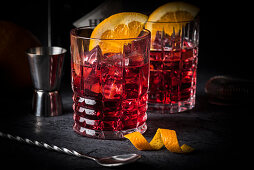 Classic Italian cocktail: Negroni on ice with oranges in glasses