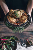 Persons Hands wth Corn muffins bread with leaf of chard