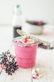 Elderberry mousse with dried rose petals and meringue in a glass