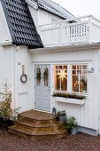 White, Swedish house with Christmas decorations around front door