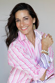 A dark-haired woman wearing a striped shirt blouse