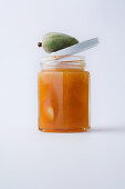 A glass of almond jam against a white background