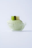 Kiwi sorbet in a glass bowl against a white background