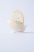 Lemon sorbet in a glass bowl against a white background
