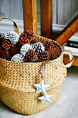Basket with pine cones and star pendants as a Christmas decoration