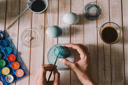 Hands of person painting the egg decoration for easter