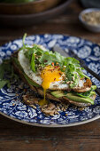 Toast mit Avocado, Spiegelei, Rucola und Sonnenblumenkernen