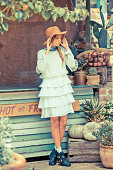 A young woman wearing a hat and a light blue dress